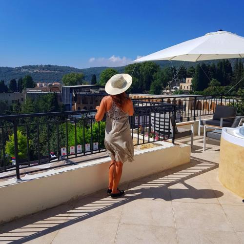 a woman in a hat is standing on a balcony at Beit Lebbos Boutique Hotel in Beït ed Dîne