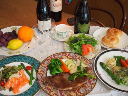 a table with plates of food and bottles of wine at Kunsthaus in Biei