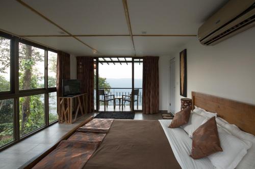 sypialnia z łóżkiem i widokiem na ocean w obiekcie Chateau Woods w mieście Kalpatta