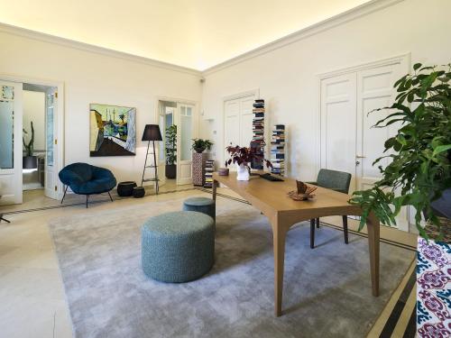 a living room with a wooden table and a blue chair at Relais San Giuliano in Viagrande