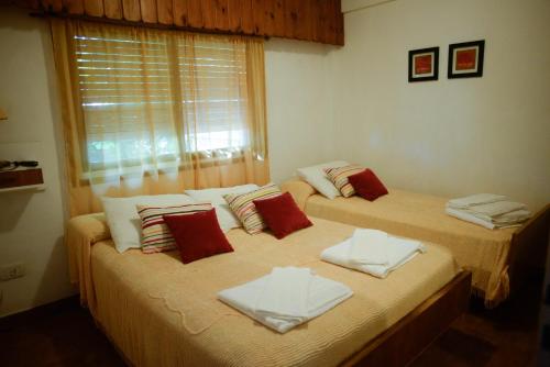 2 camas individuales en una habitación con ventana en Hostería Costa Blava en Villa Gesell