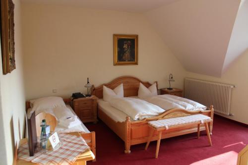 a bedroom with two beds and a table at Hotel Knorre in Meißen