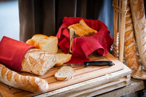 um monte de pão em uma tábua de corte com uma faca em Les Loges Blanches Megève em Megève