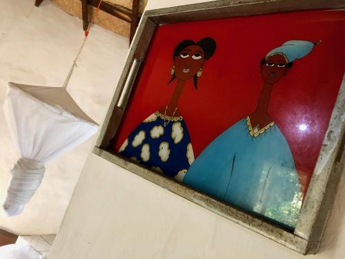 a painting of two women in a box at Nemasu Eco-lodge in Gunjur