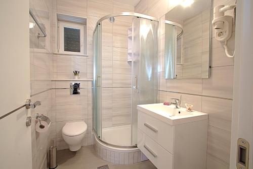 a bathroom with a shower and a sink and a toilet at Guest house Burin in Mlini