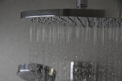une douche avec eau égouttée d'un robinet dans l'établissement meerZEIT Norderney, à Norderney