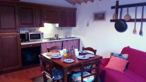 a kitchen with a small table and a kitchen with a table and a table at San Lorenzo Agriturismo in Buonconvento