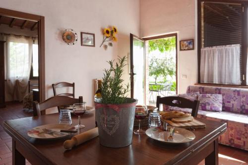 a dining room table with plates and a plant on it at San Lorenzo Agriturismo in Buonconvento