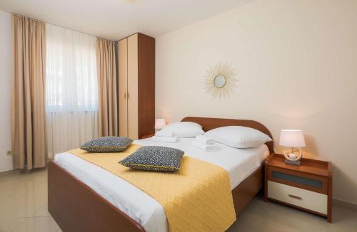a bedroom with a bed with two pillows on it at Lavica Seaside Apartments, Podstrana in Podstrana