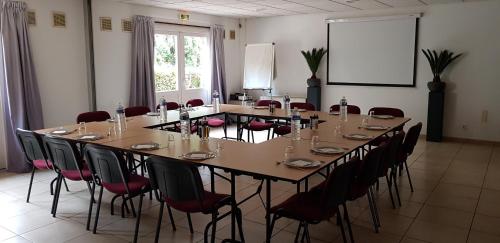une grande salle de conférence avec une grande table et des chaises dans l'établissement Doubs Hotel - Besançon Ecole Valentin, à Besançon