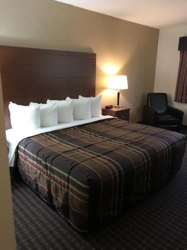 a hotel room with a large bed and a chair at Nichols Inn of Red Wing in Red Wing