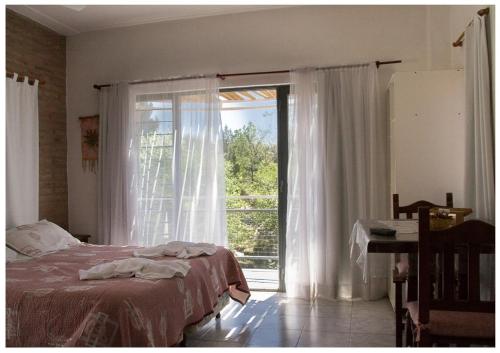 Balcón del Diquecito في فيلا كارلوس باز: غرفة نوم بسرير ونافذة كبيرة