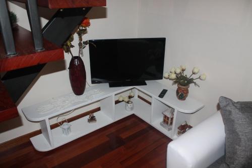 een woonkamer met een tv op een witte tafel bij Dimora di Mara in Santeramo in Colle