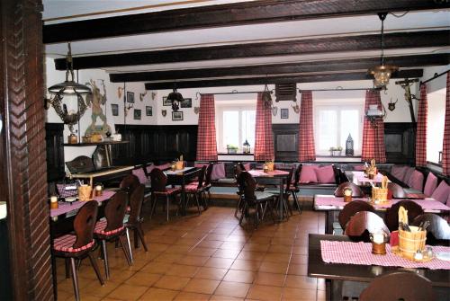 una sala da pranzo con tavoli, sedie e finestre di Landhotel Römerkessel a Landsberg am Lech