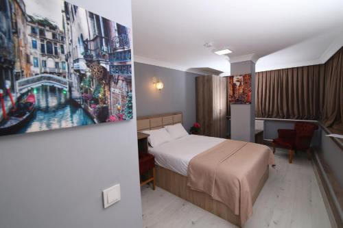 une chambre d'hôtel avec un lit et un tableau sur le mur dans l'établissement kocatepe hotel, à Ankara