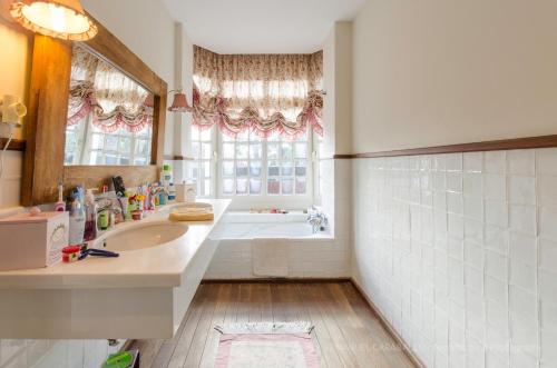 ein Badezimmer mit Badewanne, Waschbecken und Spiegel in der Unterkunft Maspalomas Golfside Luxury Villa in San Bartolomé de Tirajana