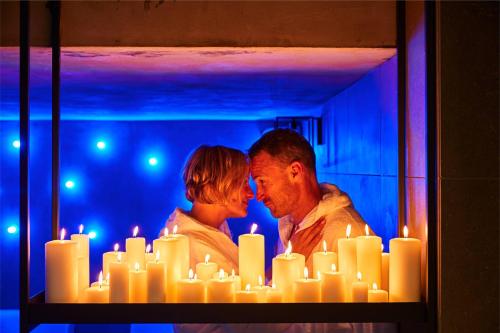 a man and a woman standing in front of candles at Hotel Europa Monetti in Cattolica