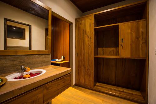 a bathroom with a sink and a counter with a mirror at Seken Cottages Ubud in Ubud