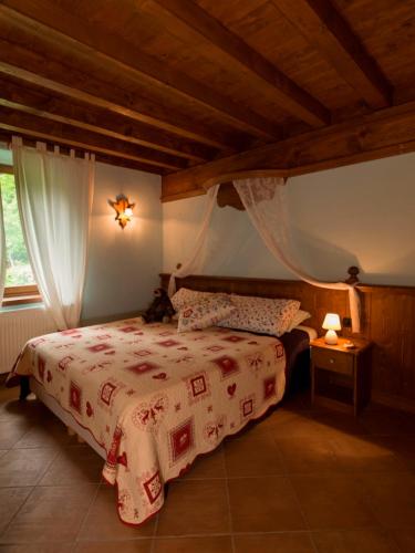 a bedroom with a bed with a red and white blanket at B&B Villa Ca'Praja in Daone