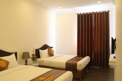 una camera d'albergo con due letti e una finestra di Arapang Hotel 2 a Da Lat