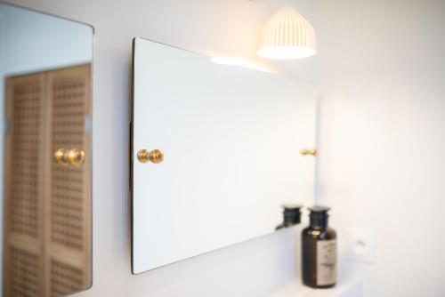 a bathroom sink with a mirror and a bottle of soap at La Maison Deveney Mars in Puligny-Montrachet