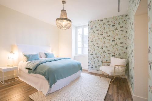 a bedroom with a bed and a chair and a window at La Maison Deveney Mars in Puligny-Montrachet