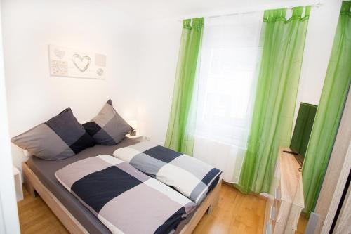 a bedroom with a bed with green curtains at Ferienwohnung BECKENDORF in Losheim