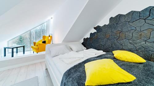 a bedroom with a bed with yellow pillows at Apartamenty Sun & Snow Karpacz Konopnickiej in Karpacz
