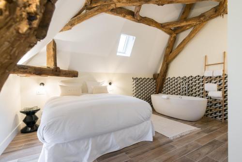 a bedroom with a white bed and a bath tub at La Maison Deveney Mars in Puligny-Montrachet