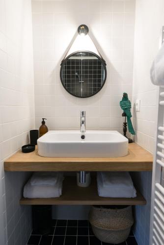 a bathroom with a sink and a mirror on the wall at La Maison Deveney Mars in Puligny-Montrachet