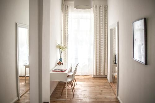 a white room with a table and chairs and a window at Pension Absolut Berlin in Berlin