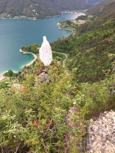 a statue on top of a hill near a body of water at Ledro Lake Suite "Pur" in Mezzolago