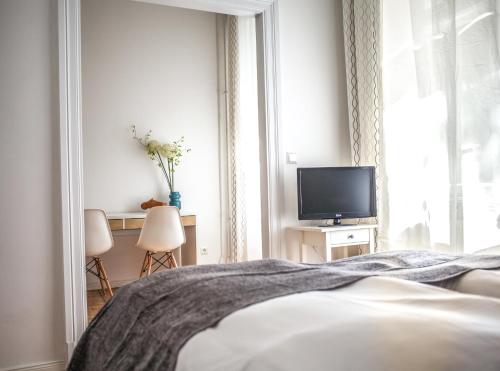 a bedroom with a bed and a tv and a window at Pension Absolut Berlin in Berlin