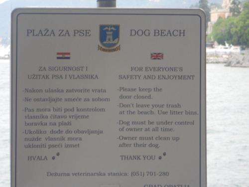 a sign for a dog beach on the water at Apartments Kolmanic, sea view, free privat parking in Ičići
