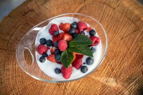 a bowl of yogurt with berries on a wooden table at Agriturismo Malga Piè in Soraga
