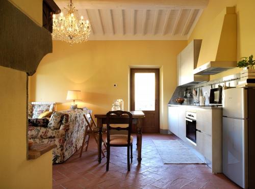 a kitchen with a table and a dining room at Podere Terreno alla via della volpaia in Radda in Chianti