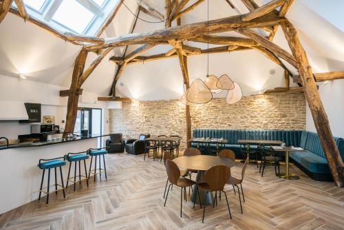 a dining room with tables and chairs and a brick wall at La Maison Deveney Mars in Puligny-Montrachet