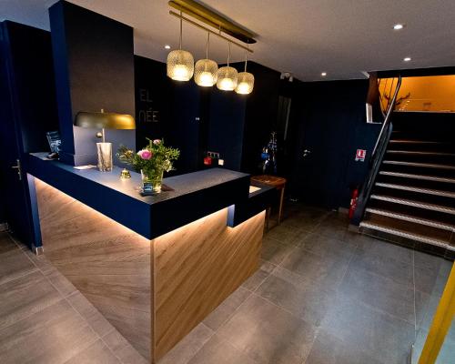 une cuisine avec un comptoir fleuri et un escalier dans l'établissement ATH hôtel Athénée, à Cannes