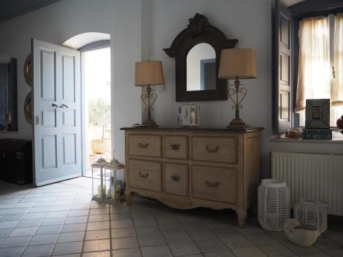 a room with a dresser with two lamps and a mirror at Palio Limani (Old Harbour) in Spetses