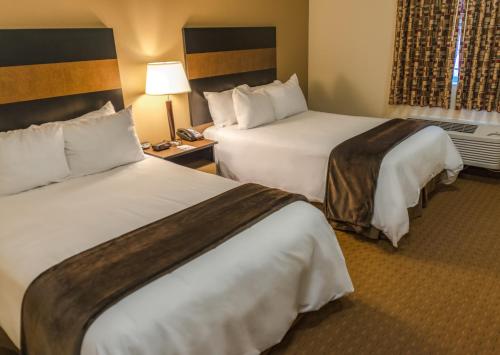 una camera d'albergo con due letti e una lampada di My Place Hotel-Dickinson, ND a Dickinson
