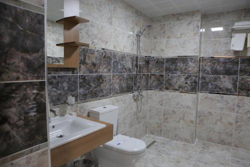 y baño con aseo, lavabo y ducha. en KORKMAZ OTEL, en Merzifon