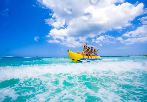 a group of people riding on a yellow raft in the ocean at Huvan Beach Hotel at Hulhumale in Hulhumale