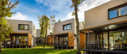 a modern house with glass doors and trees at Aminess Younique Gaia Green Villas in Njivice