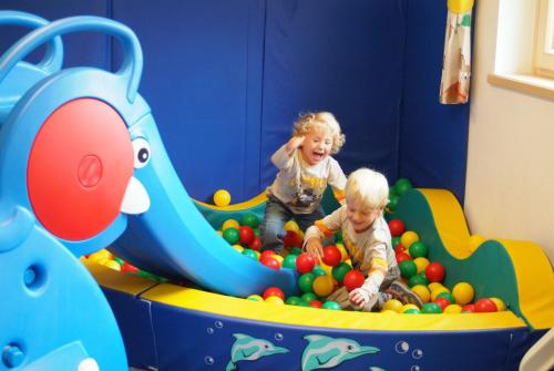 two young children playing in a play room at Landhaus & Appartementhaus Haussteiner in Dorfgastein