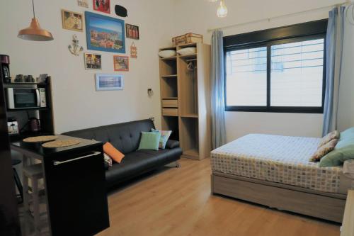 uma sala de estar com um sofá e uma cama em Lovely Studio in the Heart of Malaga FREE SWIMMING POOL em Málaga