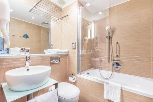 a bathroom with a sink and a shower and a toilet at Mercure Gdańsk Stare Miasto in Gdańsk