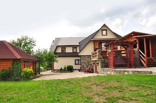 a home with a log cabin and a house at Girskiy Svitanok in Slavske