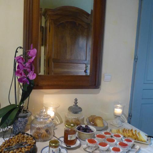 Una mesa con comida y velas y un espejo. en Domaine De La Mouthe, en Saint-Rémy