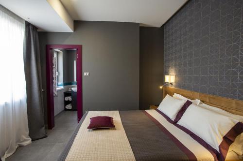a bedroom with a large bed with a brick wall at La Vigna Hotel in Bonea