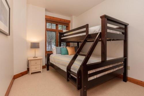 a bedroom with two bunk beds and a window at Cabins 13 in Old Mammoth